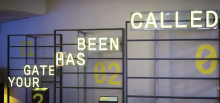 artistic arangement of neon lights reading "your gate has been called"